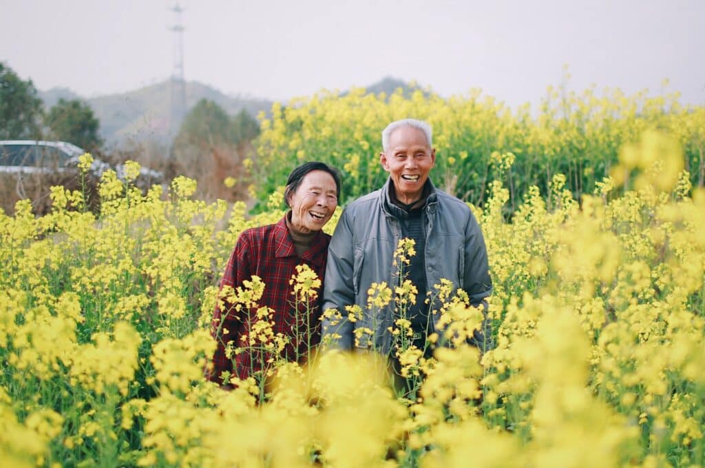 Happy couple in a fiend of yellow flowers