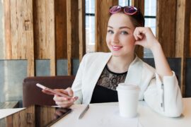 Business woman with coffee, phone, pen, and tablet