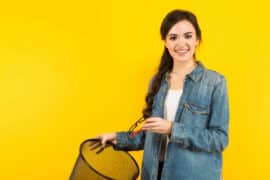 Young woman with glasses and trash bin