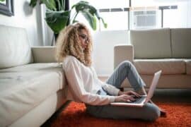 Woman sitting on the floor working on a laptop