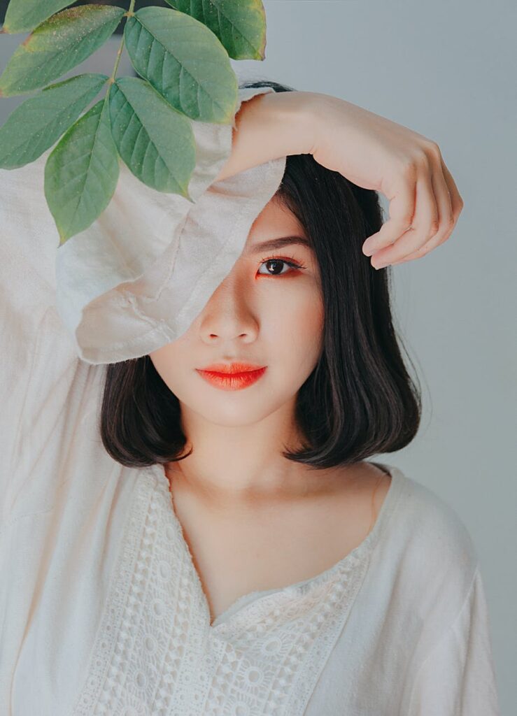 Woman with her arm over head under a plant