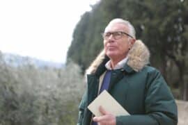 Older man outside with a book