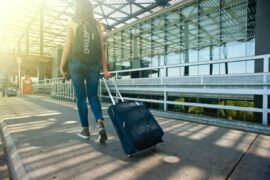Woman entering airport with suitcase